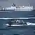 Iranian speedboat in front of cargo ships