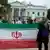 Frente a la Casa Blanca, manifestantes sostienen una bandera de Irán.