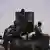 Three armed Nigerian army soldiers on the back of a military vehicle on patrol