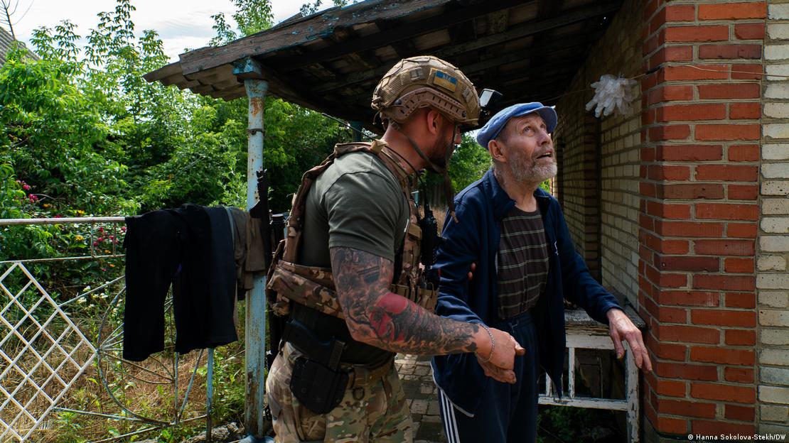 Поліцейський Дмитро супроводжує незрячого дідуся до евакуаційної автівки, Костянтинівка, Донецька область, червень 2025 року