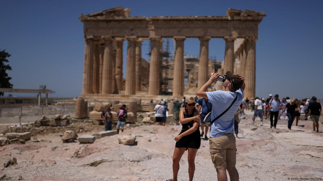 Un turista bebe agua durante su visita al templo del Partenón, en la cima de la colina de la Acrópolis, en Atenas, Grecia (27.06.2025)
