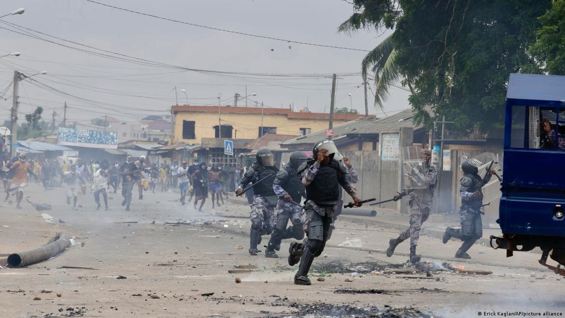 Des policiers en tenue anti-émeutes affrontent des manifestants.
