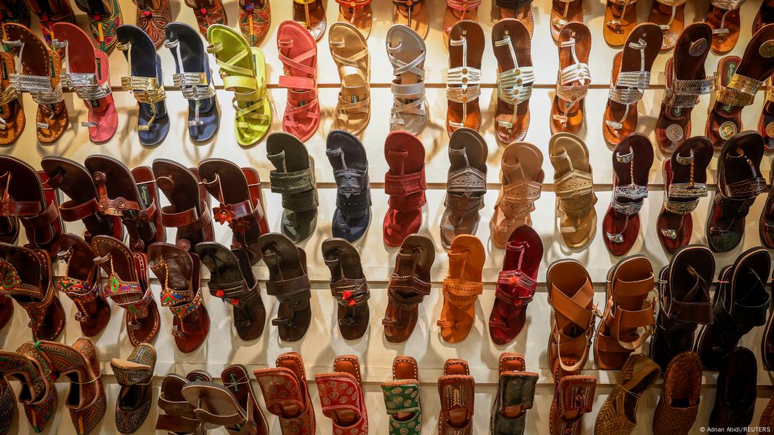 'Kolhapuri' sandals, an Indian ethnic footwear, are on display on a white wall in a store.