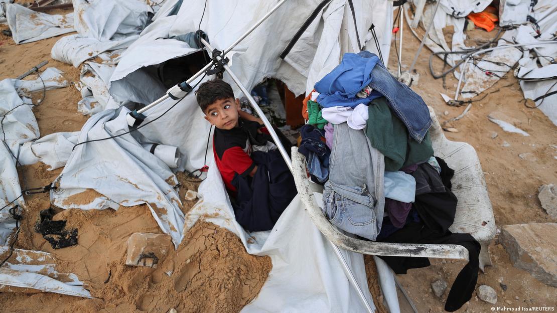 Gazze'de tahrip edilen bir çadırın önünde bekleyen çocuk. 