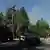 Ein gepanzertes Fahrzeug und zwei Polizeiwagen auf einer Straße