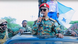 Ayub Abdirizak in a car's moonroof, wearing sunglasses and a microphone and talking to supporters