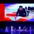 An image of North Korean leader Kim Jung Un displayed above a stage on which dancers are performing at a ceremony in Pyongyang