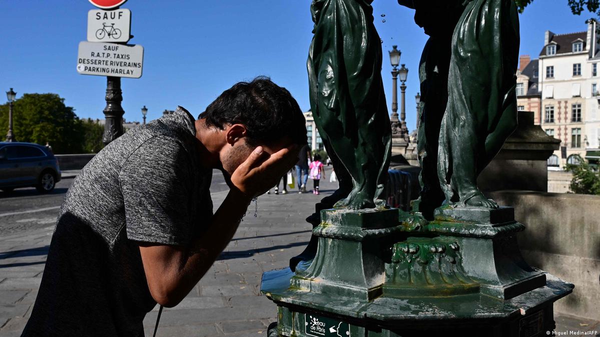 A man splashes water in his face at a fountain, Paris, France