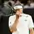 Alexander Zverev fasst sich mit Tennisschläger in der Hand nachdenklich an die Nase