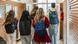 Alunos adolescentes com mochilas nas costas caminham por corredor escolar com extintor de incêndio ao fundo Alunos adolescentes com mochilas nas costas caminham por corredor escolar com extintor de incêndio ao fundo