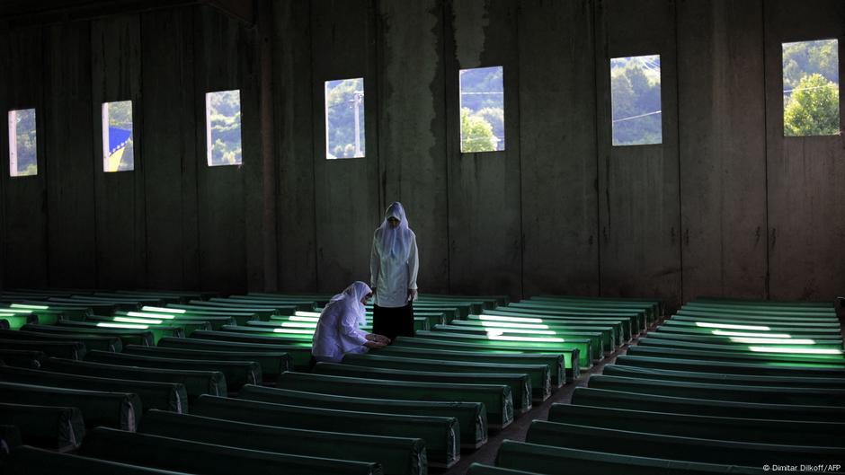 Potočari kod Srebrenice: Dve žene s belim maramama na glavi stoje pored tabuta poređanih u redovima u hangaru