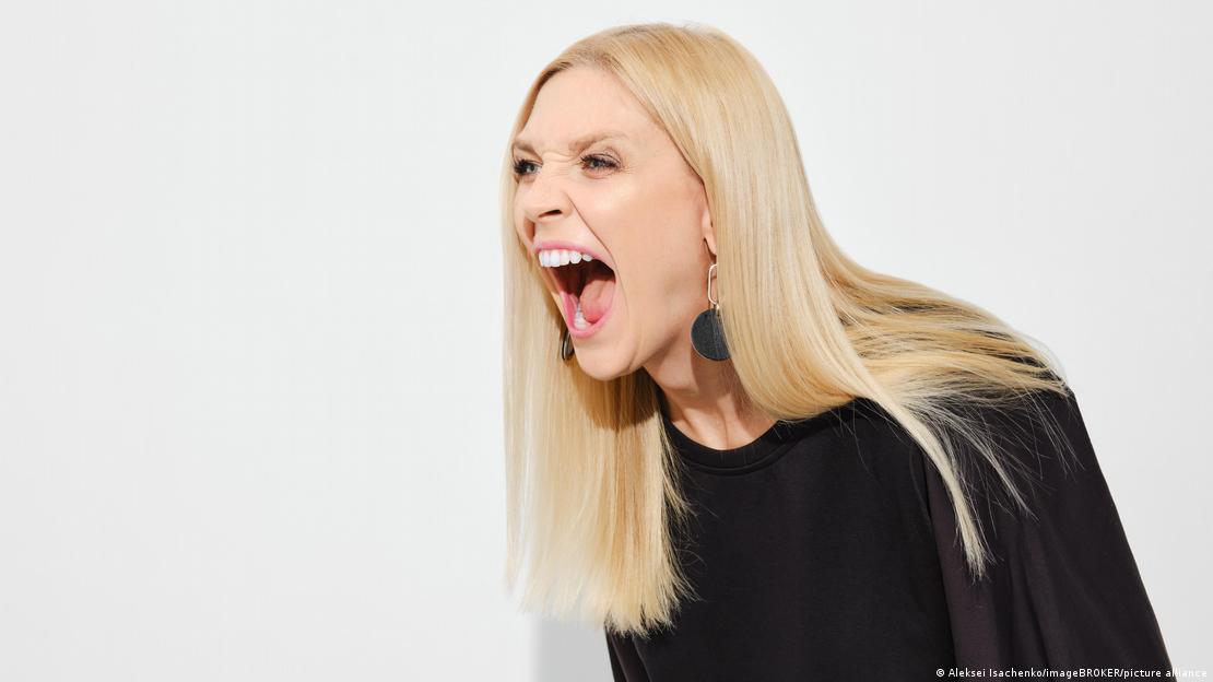 Eine junge Frau mit langen blonden Haaren schreit Eine junge Frau mit langen blonden Haaren schreit