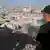Wearing a cap and a black t-shirt, Mahmoud Qassem, Khader's father, looks out over the tents of displaced families.
