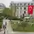 Boğaziçi Üniversitesi'nin bahçesi. Çimenlerde öğrenciler oturuyor, üniversite binasının üzerinde de Türk bayrağı asılı 