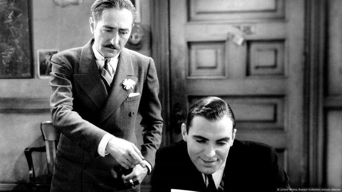 El actor estadounidense Adolphe Menjou (izq.), cuyo elegante bigote inspiró el estilo inicial de Salvador Dalí, junto a Pat O'Brien en la película "The Front Page" (1931). El actor estadounidense Adolphe Menjou (izq.), cuyo elegante bigote inspiró el estilo inicial de Salvador Dalí, junto a Pat O'Brien en la película "The Front Page" (1931).