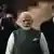 Plano corto de Narendra Modi, junto a personal de seguridad que aparece desenfocado detrás.