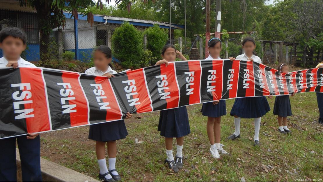 Estudiantes nicaragüenses de primaria sostienen banderas del partido Frente Sandinista mientras esperan la visita de Daniel Ortega a su colegio, ubicado en la ciudad de Juigalpa, Chontales. Estudiantes nicaragüenses de primaria sostienen banderas del partido Frente Sandinista mientras esperan la visita de Daniel Ortega a su colegio, ubicado en la ciudad de Juigalpa, Chontales.