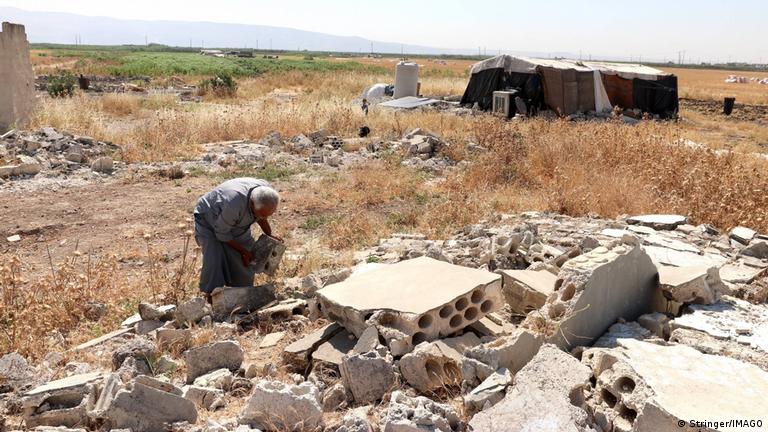 14 yıl Ürdün'de mülteci olarak yaşadıktan sonra Haziran'da ülkesine dönen Ekrem Mahmud Şehada, Hama vilayetine bağlı Kabr Fiddah'ta evinin enkazını tek başına temizlemeye çalışıyor