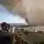 People take pictures of smoke at a lookout above Marseille