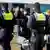 Mehrere Polizeibeamte von hinten mit Uniform und Helmen