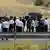 Kurdish security forces and others stand at a checkpoint, on the day of a disarmament ceremony near Sulaymaniyah, Iraq