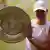Iga Swiatek, wearing white tennis clothes, poses with the Wimbledon trophy