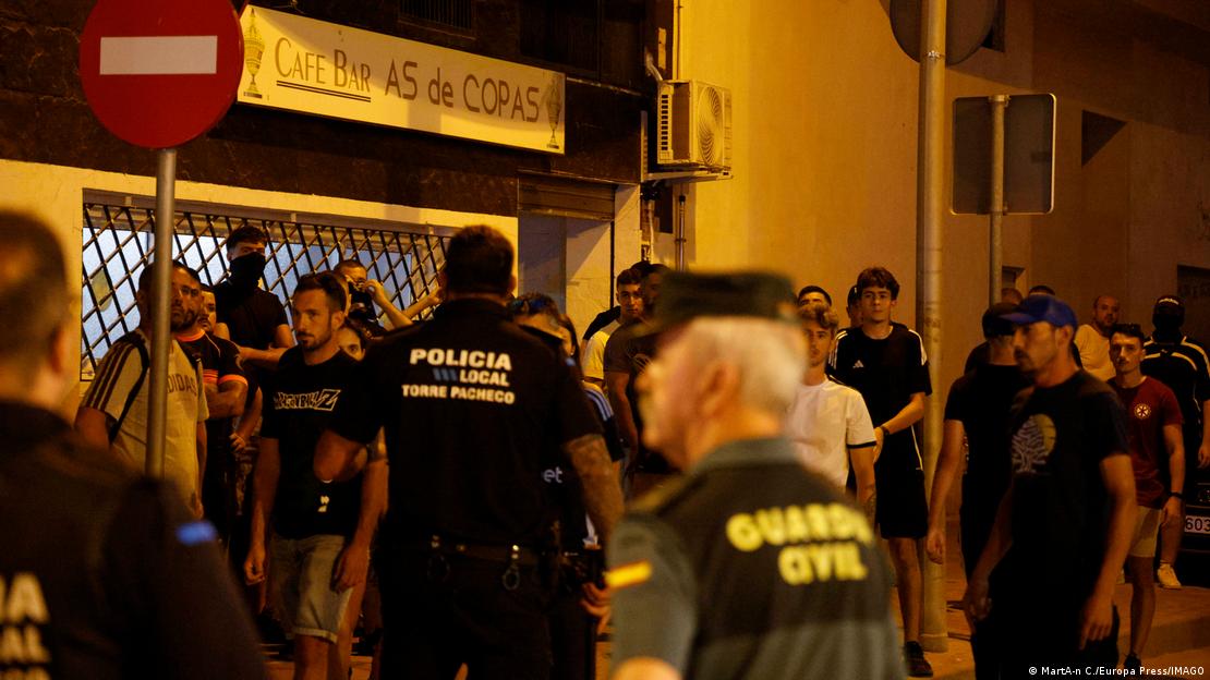 Policía y residentes en Torre Pacheco, frente a un bar.