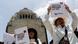 two protesters demand regulation of artificial intelligence by showing Spanish-language posters