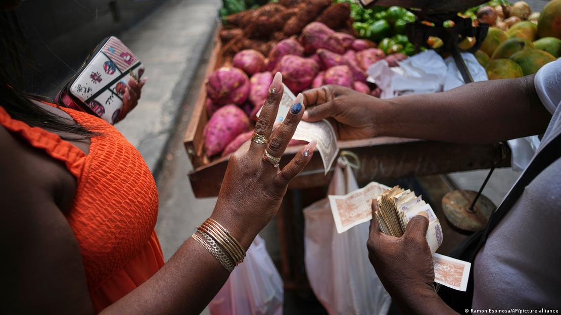 Mulher paga com notas de pesos cubanos em banca de alimentos