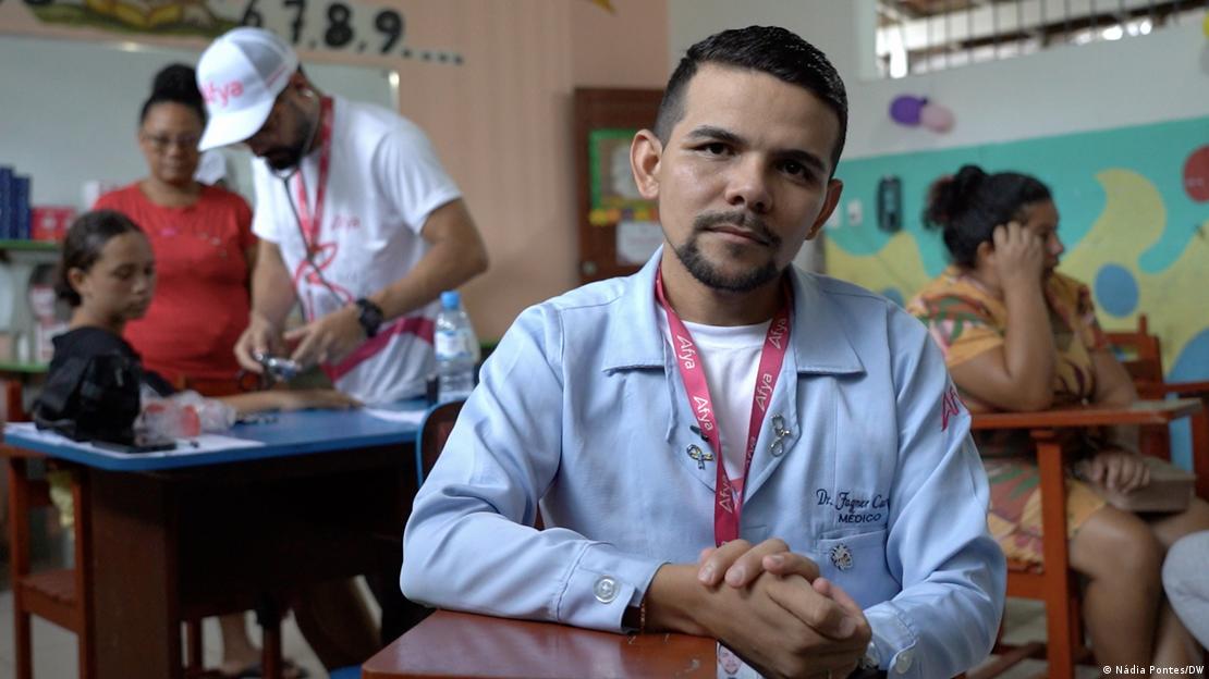 O médico infectologista Fagner Carvalho sentado em uma cadeira numa escola