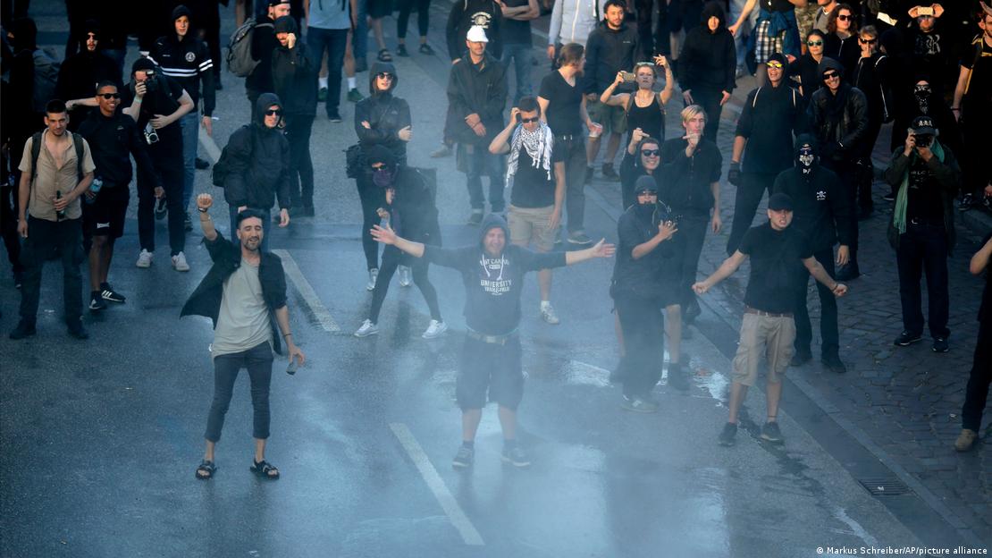 Demonstranten stehen mit erhobenen Armen auf der Straße und gestikulieren während eines Protests gegen den G20-Gipfel