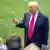Donald Trump gestures and speaks in front of reporters next to lawn at White House