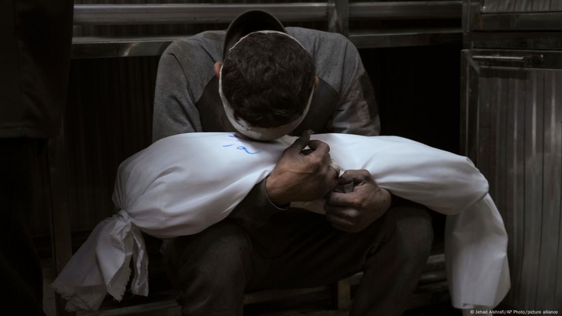 غزہ کے الشفاء ہسپتال کے باہر غمزدہ فلسطینی اپنے مارے جانے والے بچے کی لاش کے ساتھ غزہ کے الشفاء ہسپتال کے باہر غمزدہ فلسطینی اپنے مارے جانے والے بچے کی لاش کے ساتھ
