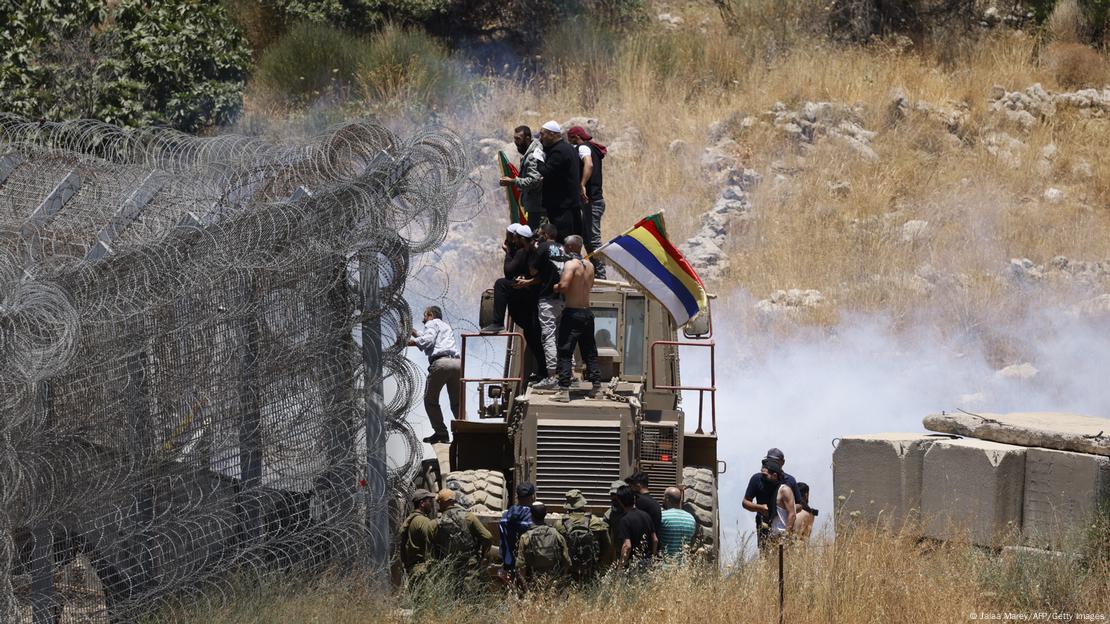 Tropas israelíes usan gases lacrimógenos para dispersar a sirios drusos que intentan cruzar hacia los Altos del Golán anexados por Israel, este 16 de julio de 2025, en medio de enfrentamientos entre combatientes drusos y tanto las tribus beduinas vecinas como las fuerzas leales al Gobierno islamista de Siria en el otro lado. Tropas israelíes usan gases lacrimógenos para dispersar a sirios drusos que intentan cruzar hacia los Altos del Golán anexados por Israel, este 16 de julio de 2025, en medio de enfrentamientos entre combatientes drusos y tanto las tribus beduinas vecinas como las fuerzas leales al Gobierno islamista de Siria en el otro lado.