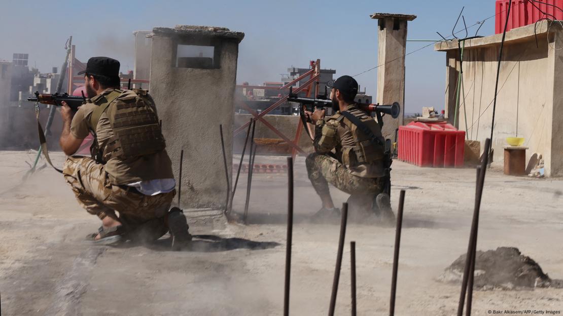 Siria, Sweida | Dos efectivos de las fuerzas de seguridad sirias parapetados en un techo, durante combates entre drusos y beduinos, además de bombardeos de Israel. Siria, Sweida | Dos efectivos de las fuerzas de seguridad sirias parapetados en un techo, durante combates entre drusos y beduinos, además de bombardeos de Israel.