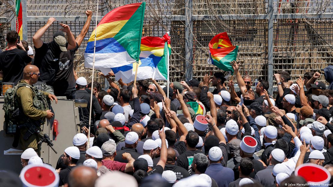 Miembros de la comunidad drusa se manifiestan ante las fuerzas israelíes junto a la valla de alambre de púas que separa a los Altos del Golán anexados por Israel de Siria, cerca de Majdal Shams, el 16 de julio de 2025. Las tropas israelíes intentaron controlar a las multitudes e impedir que los drusos cruzaran a Siria, tras la violencia mortal que enfrentó a drusos, tribus beduinas y fuerzas gubernamentales en el sur de ese país. Miembros de la comunidad drusa se manifiestan ante las fuerzas israelíes junto a la valla de alambre de púas que separa a los Altos del Golán anexados por Israel de Siria, cerca de Majdal Shams, el 16 de julio de 2025. Las tropas israelíes intentaron controlar a las multitudes e impedir que los drusos cruzaran a Siria, tras la violencia mortal que enfrentó a drusos, tribus beduinas y fuerzas gubernamentales en el sur de ese país.