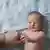 Smiling daughter touching father's hand and lying on bed at home