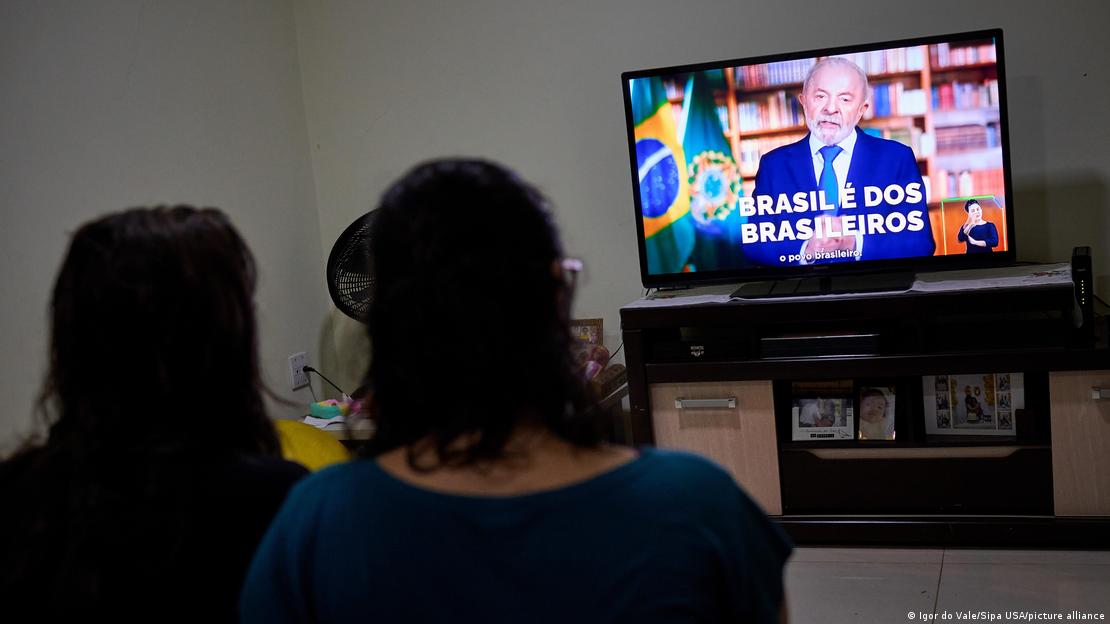 Women watch a televised speech by the President of Brazil, Luiz Inacio Lula da Silva, on the evening of July 17, 2025, in Sao Paulo