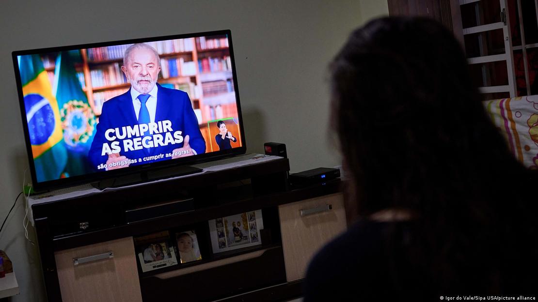 Mulher assiste declaração de Lula na TV Mulher assiste declaração de Lula na TV