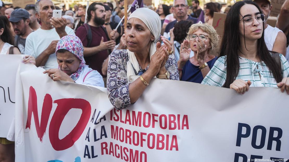 Pessoas com uma faixa contra islamofobia e racismo em manifestação pela regularização dos migrantes em Valência, em julho de 2025