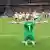 Ann-Katrin Berger kneels and stretches her arms out as her Germany teammates run towards her