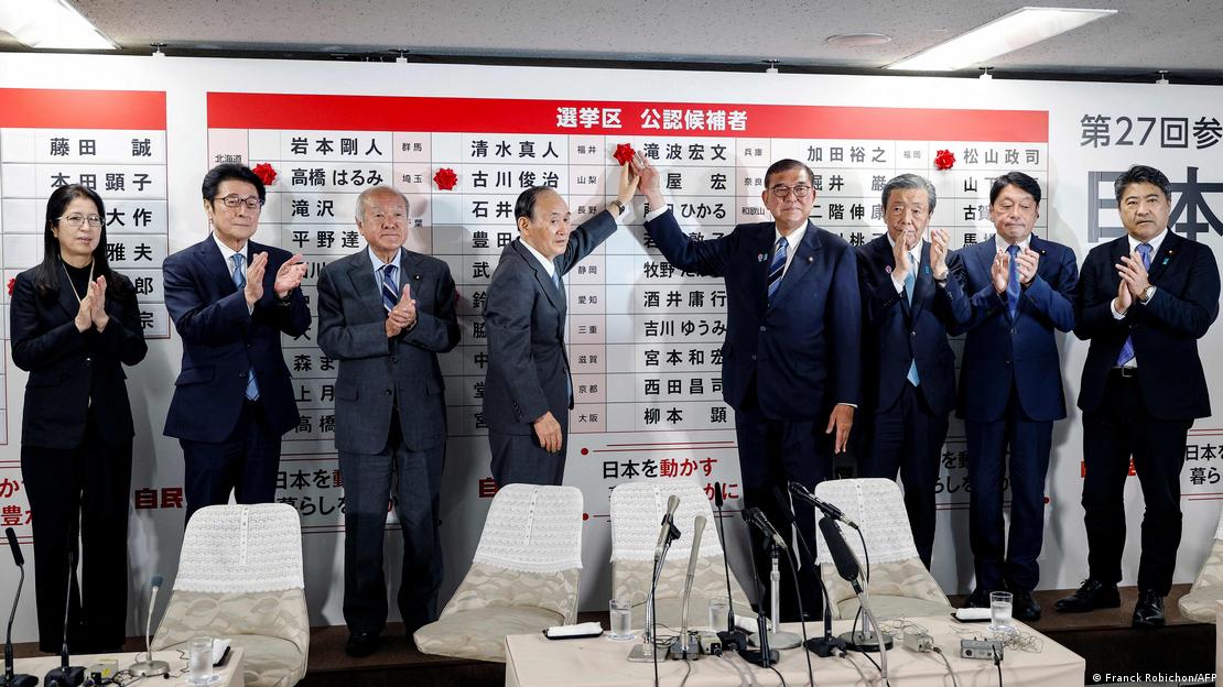 Ishiba (cuarto en la imagen de derecha a izquierda) coloca una rosa junto al nombre de un candidato en el centro de recuento de votos en la sede del Partido Liberal Democrático (PLD), en Tokio (20.07.2025)