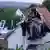 A policeman on a ladder surveys a smashed up car which is lodged in the roof of a barn after an accident