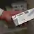 A person holds out a box of Ozempic injectable medicines