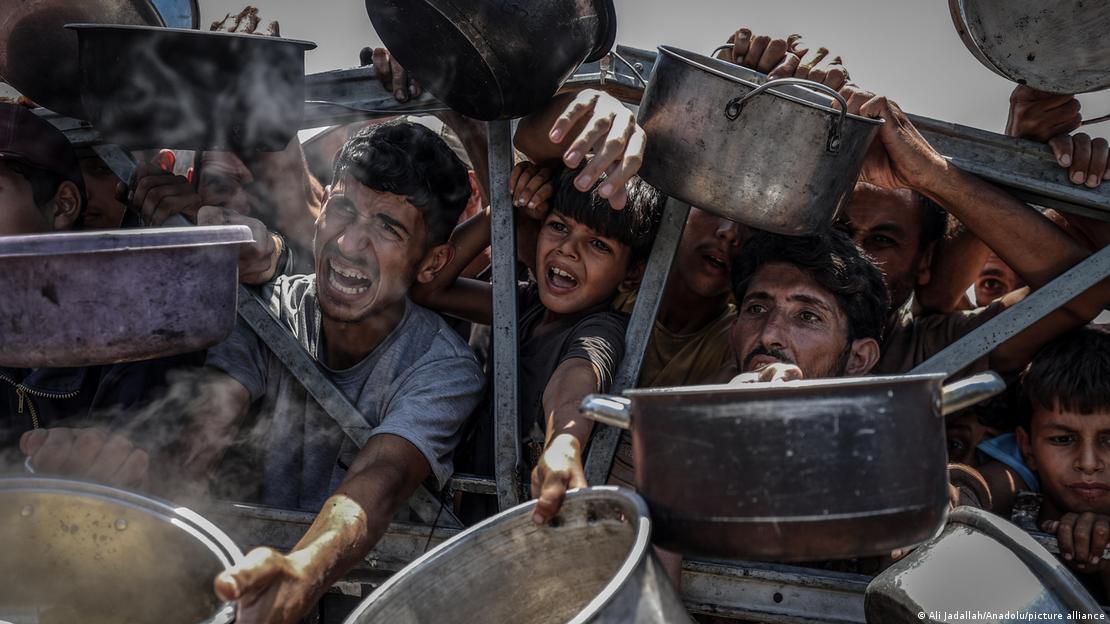Gazze'de gıda yardımı almak için tencelerini uzatan çocuklar
