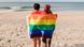 Lesbian couple at the beach with a rainbow flag Lesbian couple at the beach with a rainbow flag