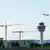 Deutschland München 2025 | Flugzeug startet am Flughafen München, im Vordergrund Baukräne und der Tower, rechts ein Terminal (30.05.2025)