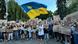Jovem tremula bandeira da Ucrânia cercado de manifestantes com cartazes durante protesto