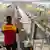 Funcionário da empresa alemã de logística DHL observa pacotes rolando sobre uma esteira