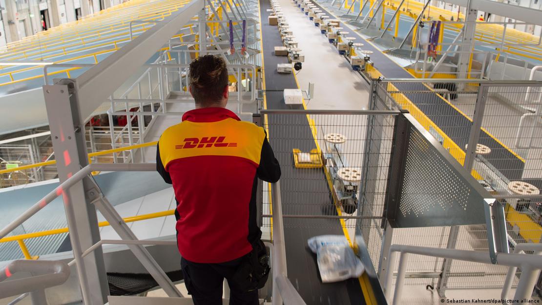 Trabalhador observa esteiras com pacotes em centro de distribuição da empresa DHL
